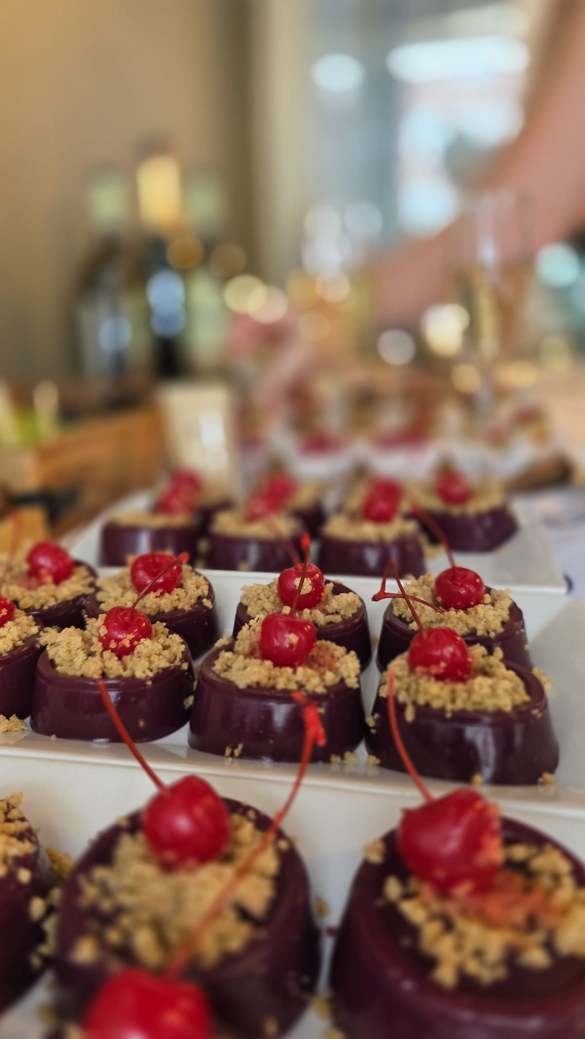 Chocolate covered sweets topped with cherries at Kolhelly Bakery